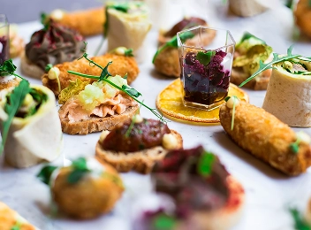 Assortiment élégant d'amuse-bouches et de plats à manger avec les doigts, joliment présentés pour un repas gastronomique.