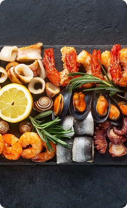 Plateau de fruits de mer méditerranéens frais avec crevettes, moules, poulpe, calamars, citron et herbes.