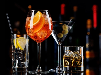 Sélection de cocktails élégants servis sur fond de bar sombre.